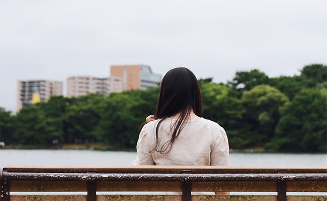 Женщина-сидит на скамейке в парке Охори-Фукуока